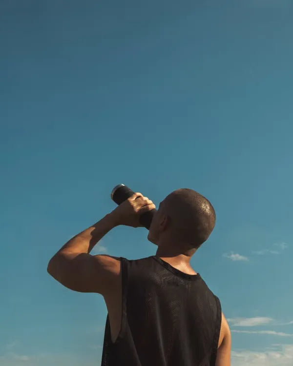 Loper drinkt water na een training op de loopband